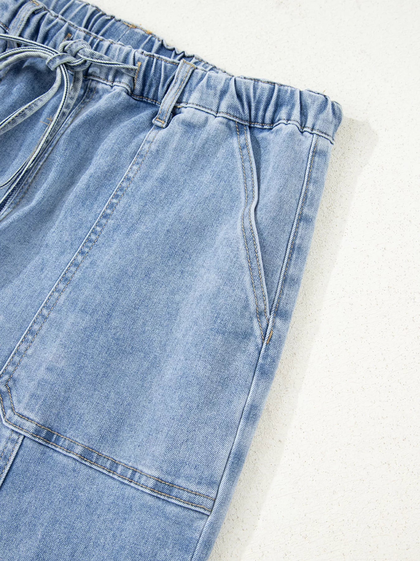 Close-up of light blue denim shorts on a white background