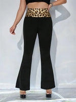 Person wearing black flared pants with a leopard print waistband on a white background