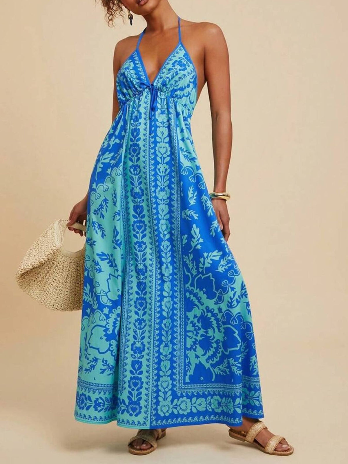 Woman wearing a blue patterned dress against a beige background