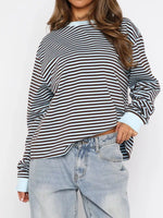 Person wearing a striped long-sleeve shirt and light blue jeans on a white background