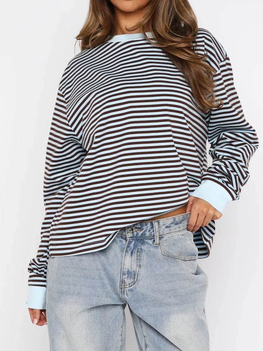 Person wearing a striped long-sleeve shirt and light blue jeans on a white background