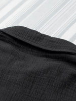 Close-up of black fabric with a textured pattern on a white background