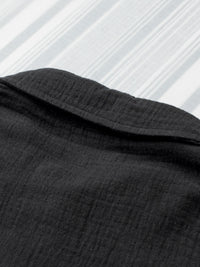 Close-up of black fabric with a textured pattern on a white background