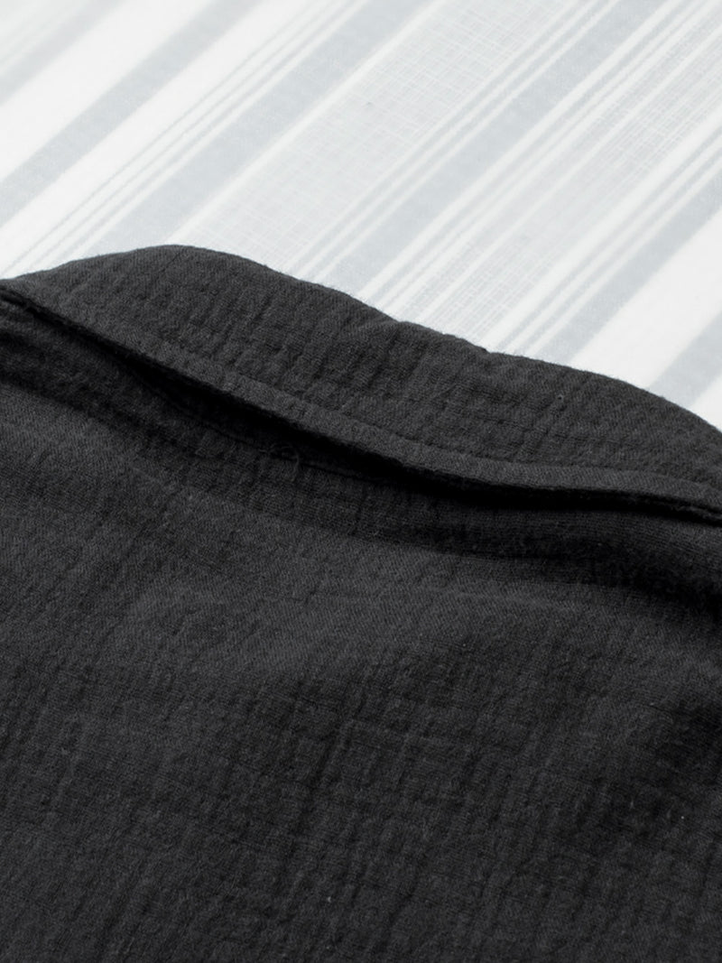 Close-up of black fabric with a textured pattern on a white background
