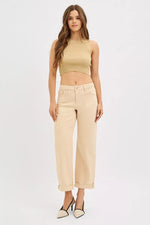 Woman wearing a beige sleeveless top and pants on a white background