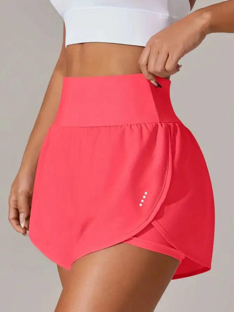 Person wearing a bright pink skirt with a plain background