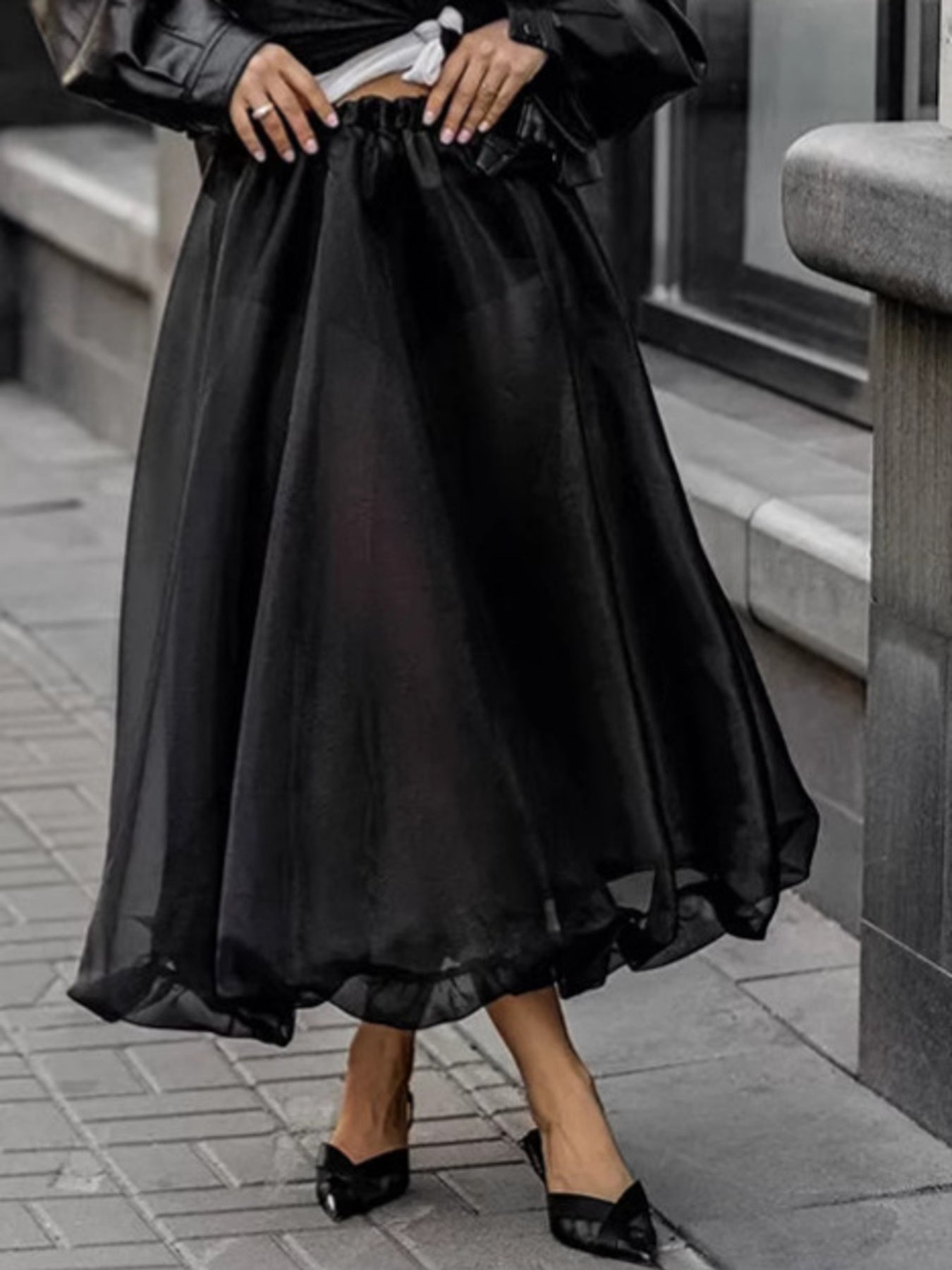 Person wearing a black sheer skirt with a blurred background