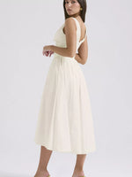 Woman wearing a white dress on a plain background