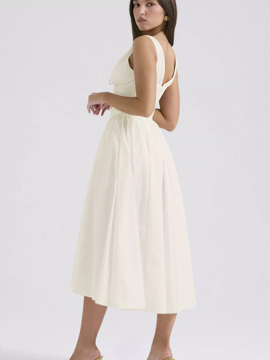 Woman wearing a white dress on a plain background