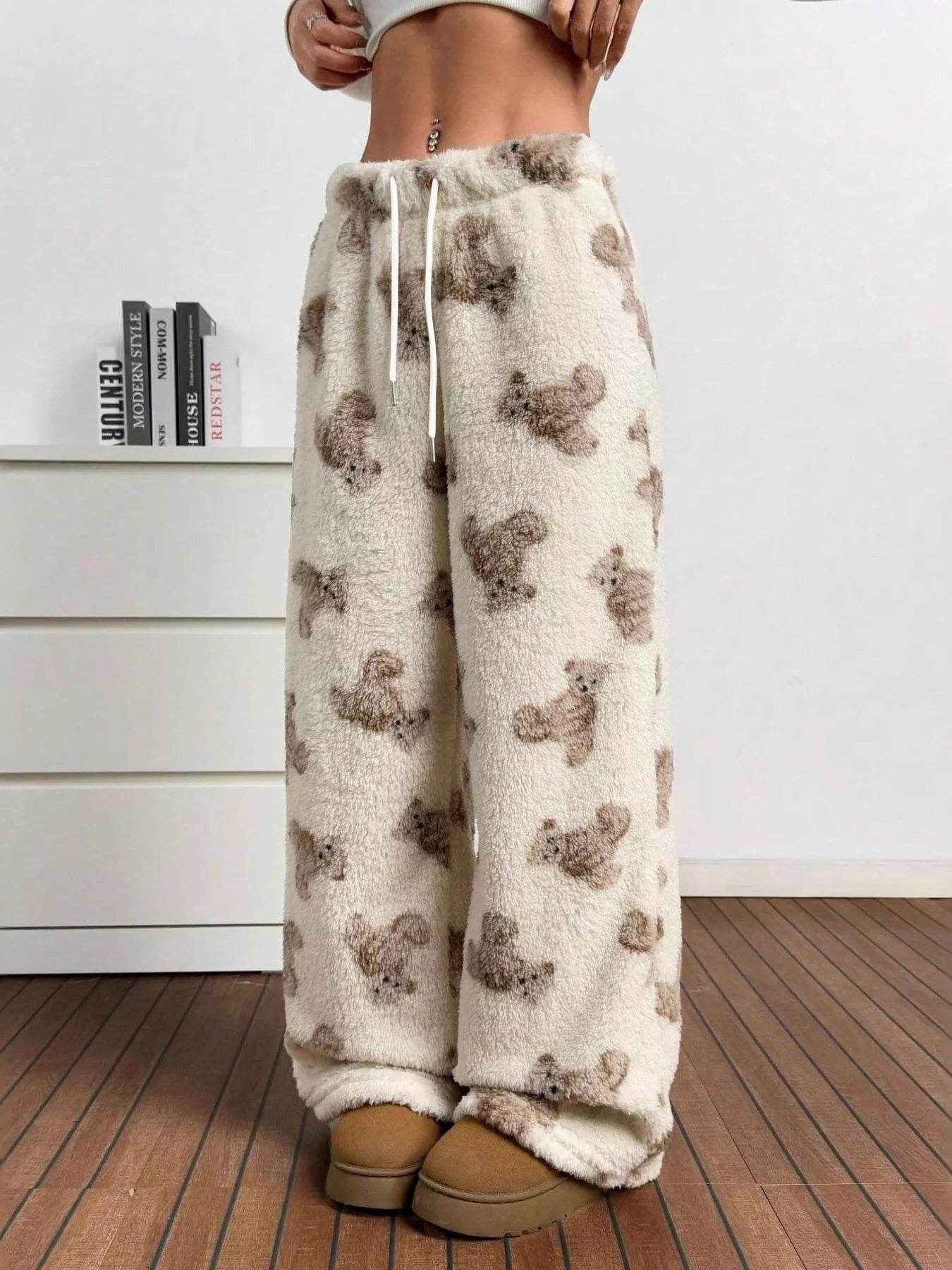 Pajama pants with bear pattern worn by a person indoors.