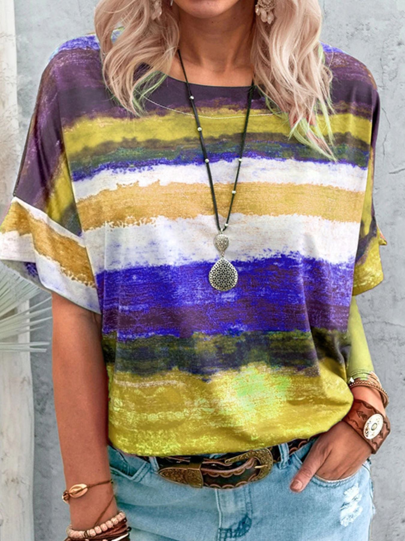 Person wearing a colorful striped shirt with a neutral background