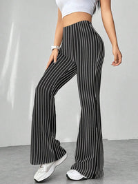 Person wearing black and white striped pants with a plain background