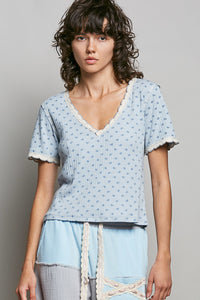 Woman wearing a light blue patterned top against a plain background