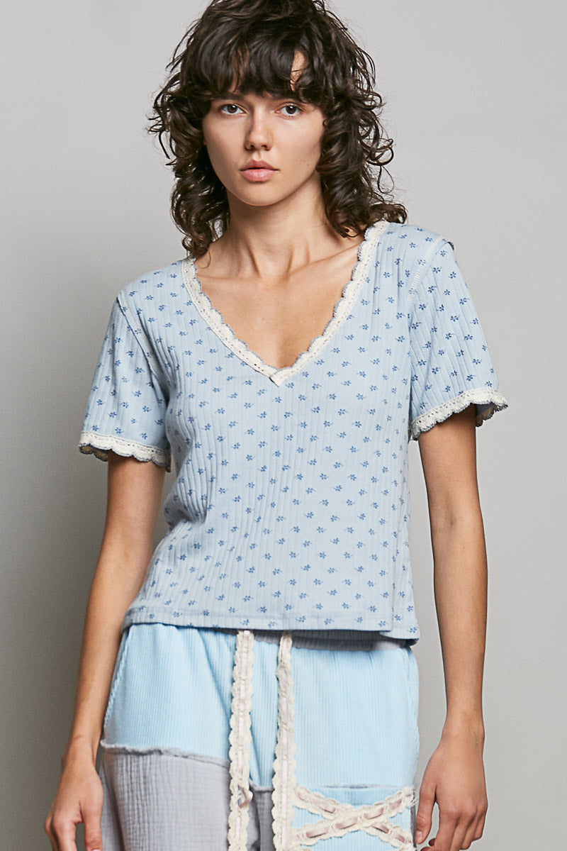 Woman wearing a light blue patterned top against a plain background