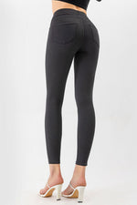 Dark gray leggings worn by a person on a white background