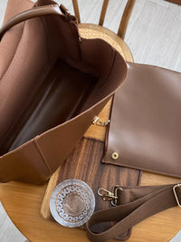 Brown leather bag with a wooden base on a wooden surface