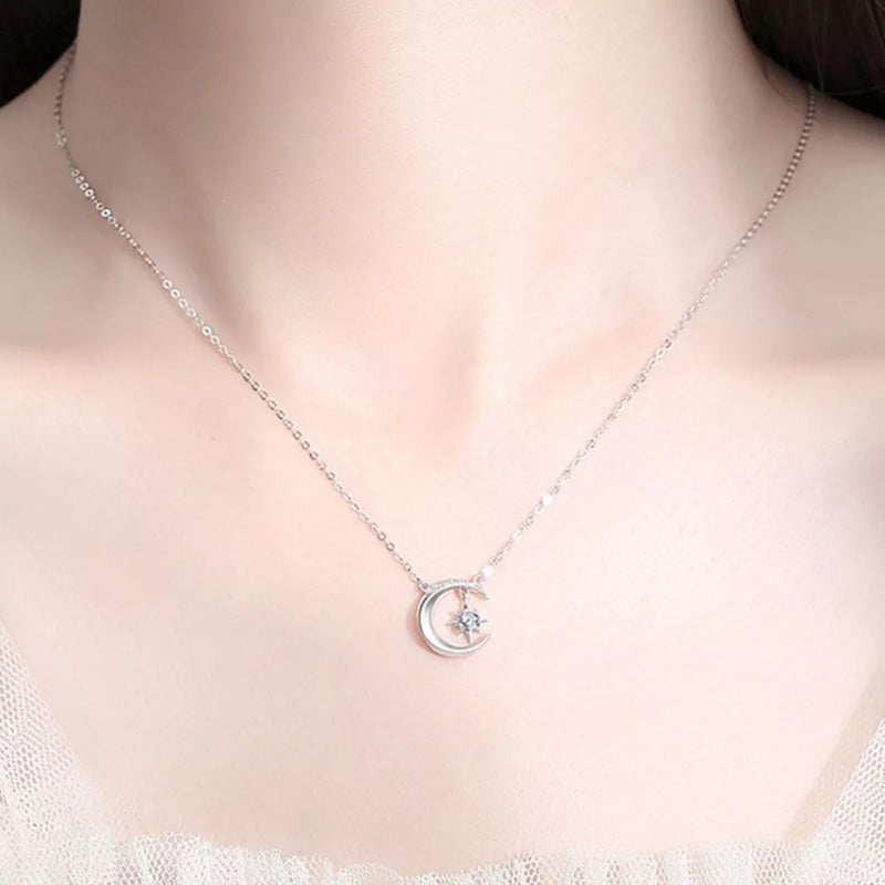 Silver necklace with a moon and star pendant on a person's neck