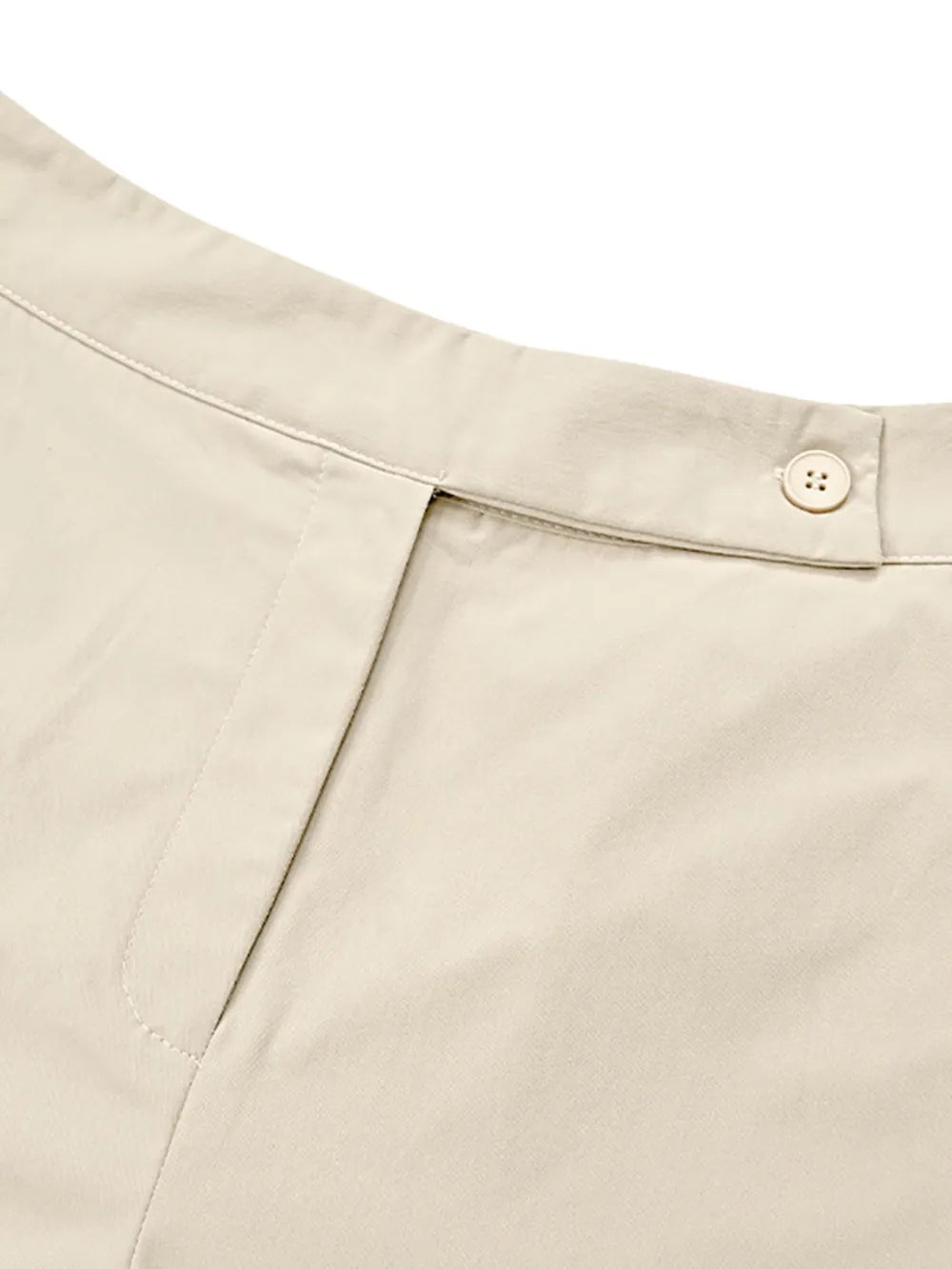 Close-up of beige pants with a button on a white background