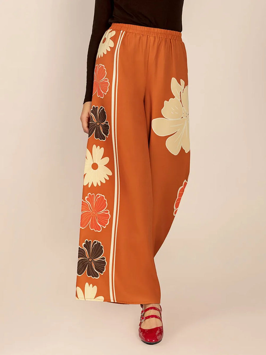 Orange pants with floral patterns on a beige background