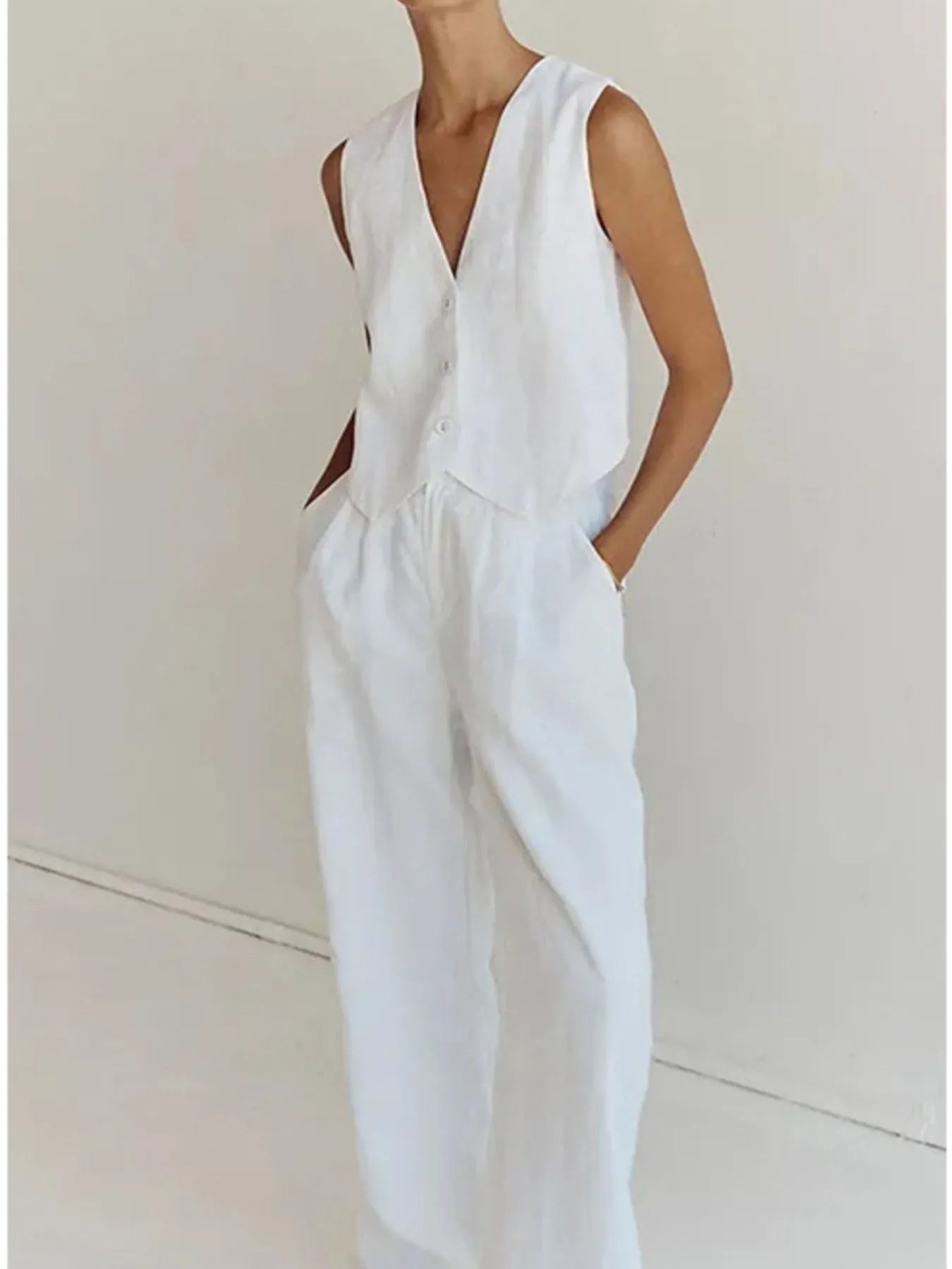 Person wearing a white sleeveless jumpsuit on a plain background