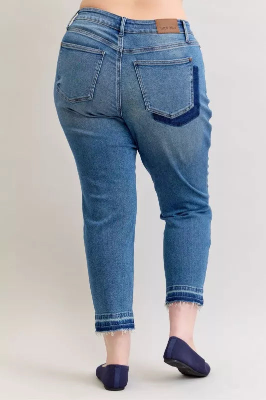 Blue jeans worn by a person on a plain background