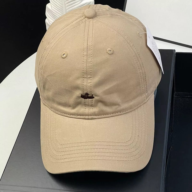 Beige cap on a black surface with a white background