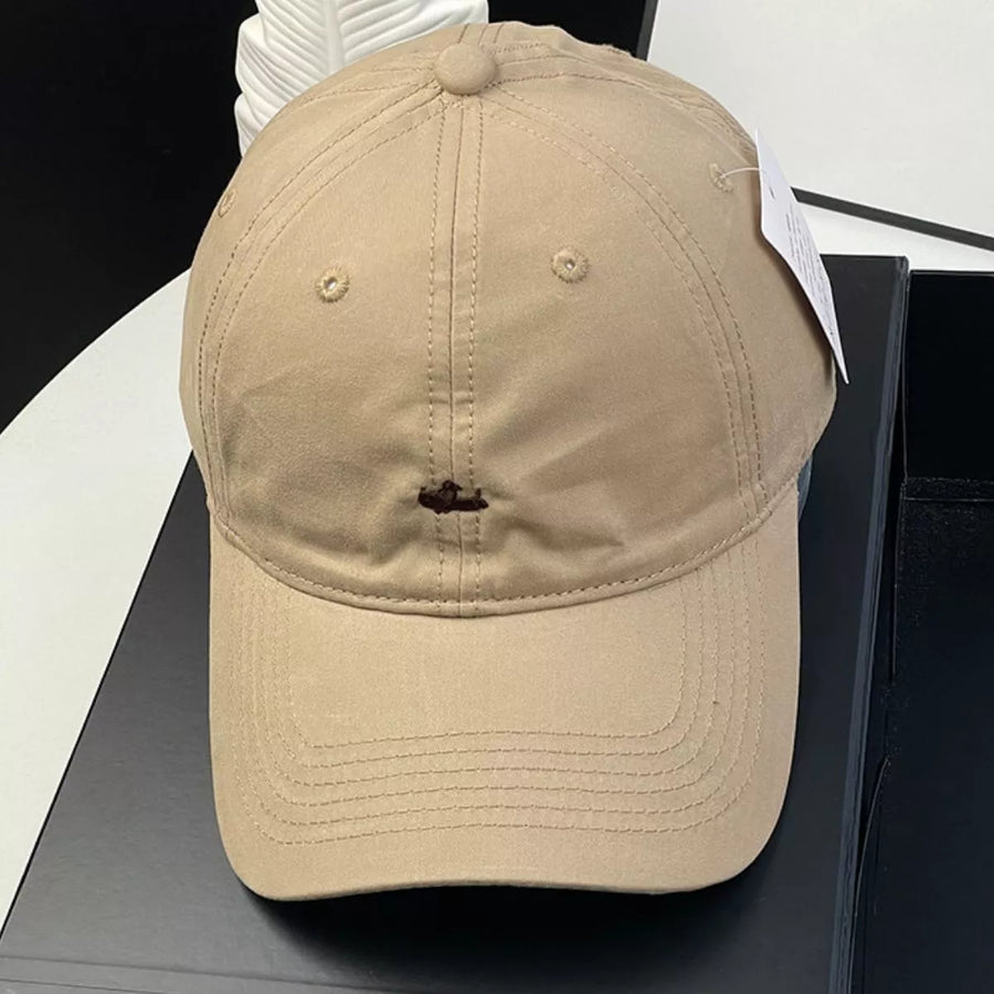 Beige cap on a black surface with a white background