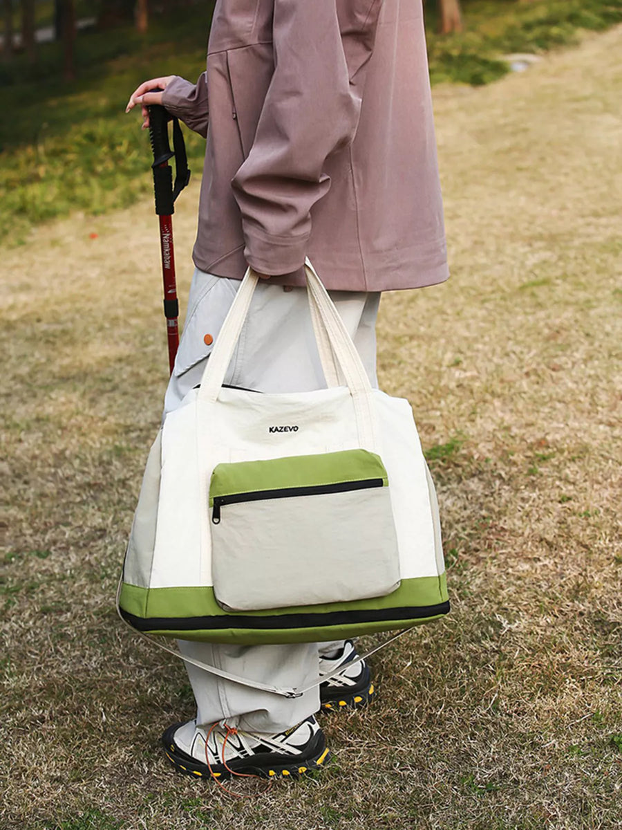 Person holding a white and green bag with 'KARL' branding outdoors on grass