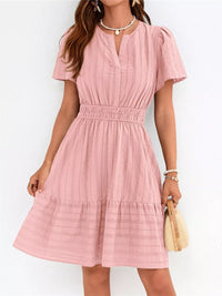 Pink dress worn by a person on a white background