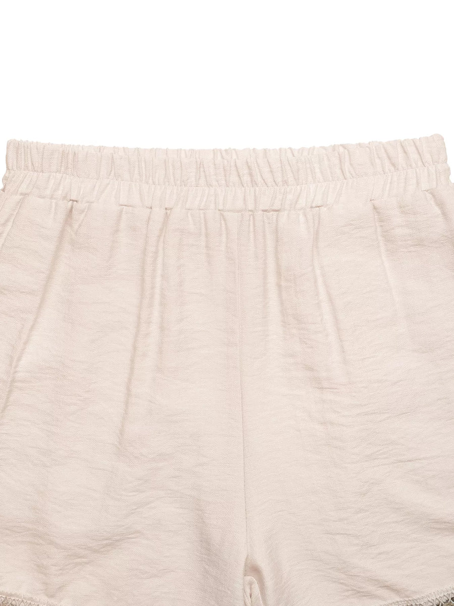 Close-up of beige shorts with a white background