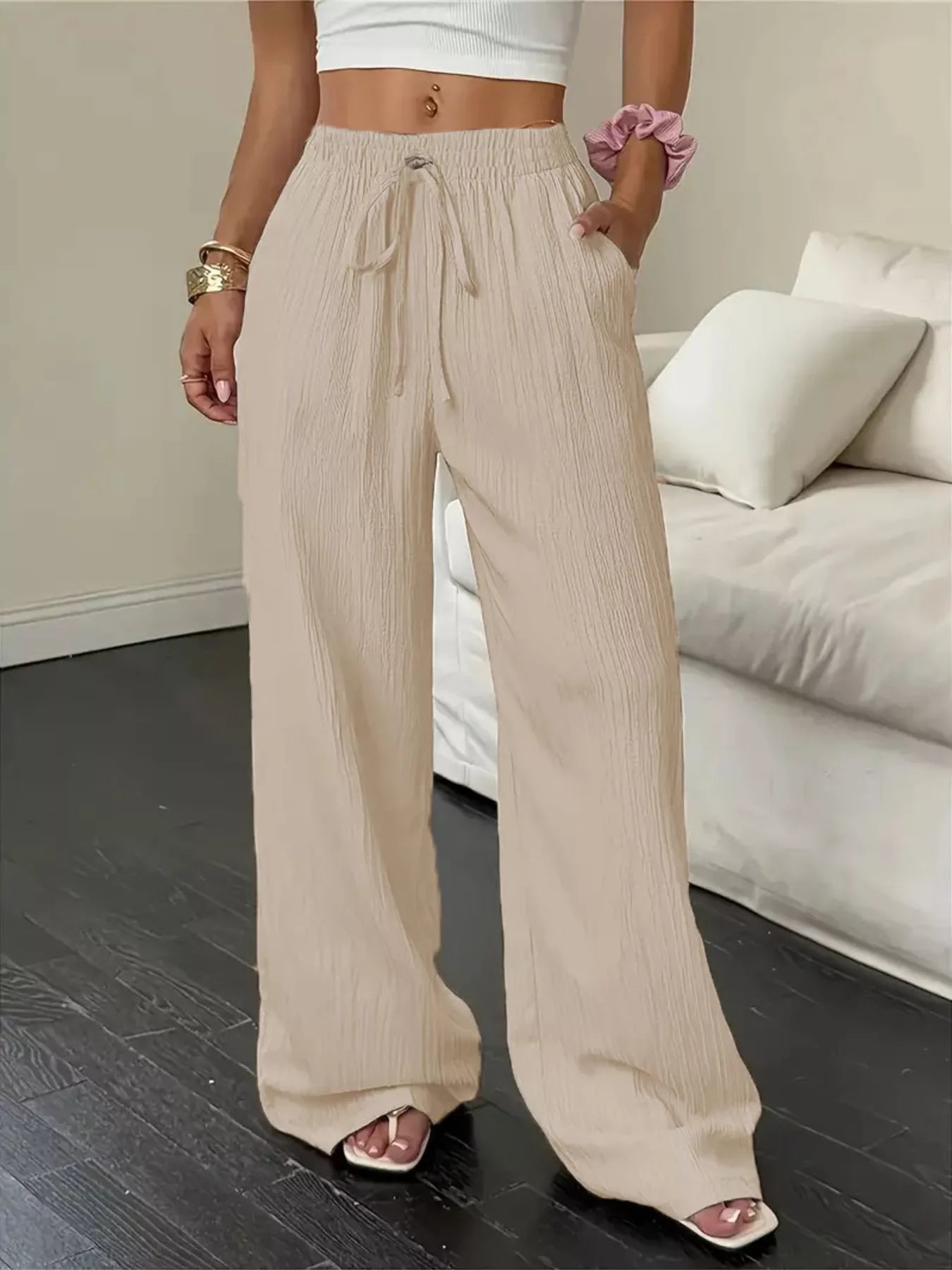 Person wearing beige wide-leg pants in a living room setting