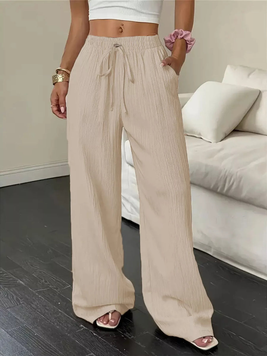 Person wearing beige wide-leg pants in a living room setting