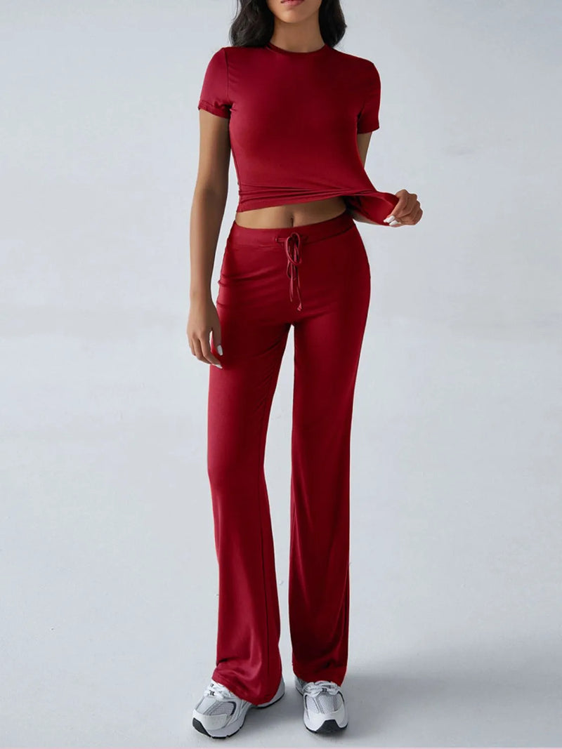 Person wearing a red outfit with a matching top and pants on a white background