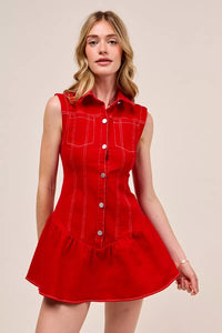 Woman wearing a red dress with white buttons on a beige background