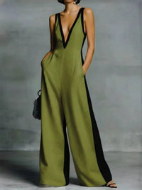 Green jumpsuit with black trim worn by a person against a gray background