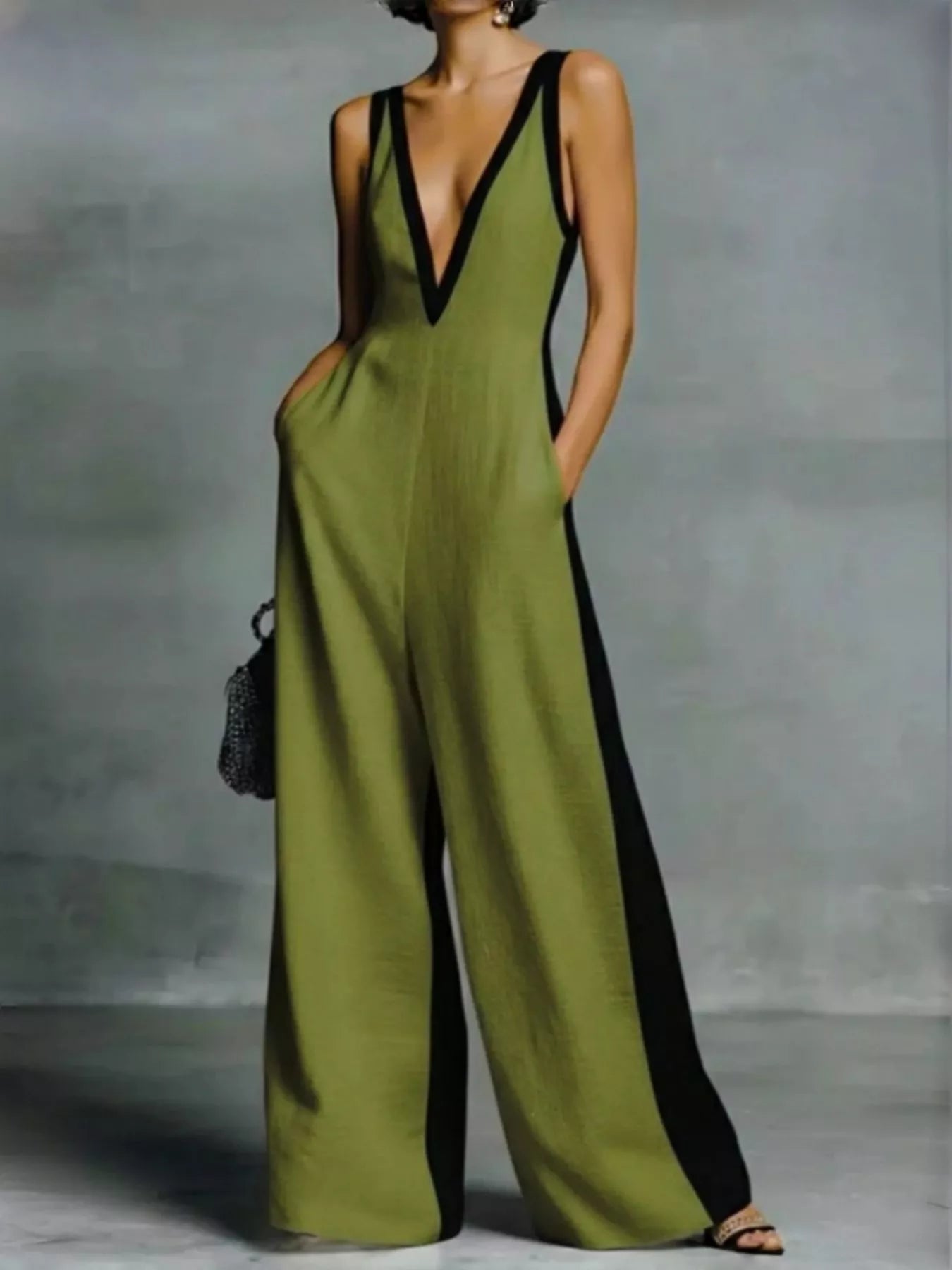 Green jumpsuit with black trim worn by a person against a gray background