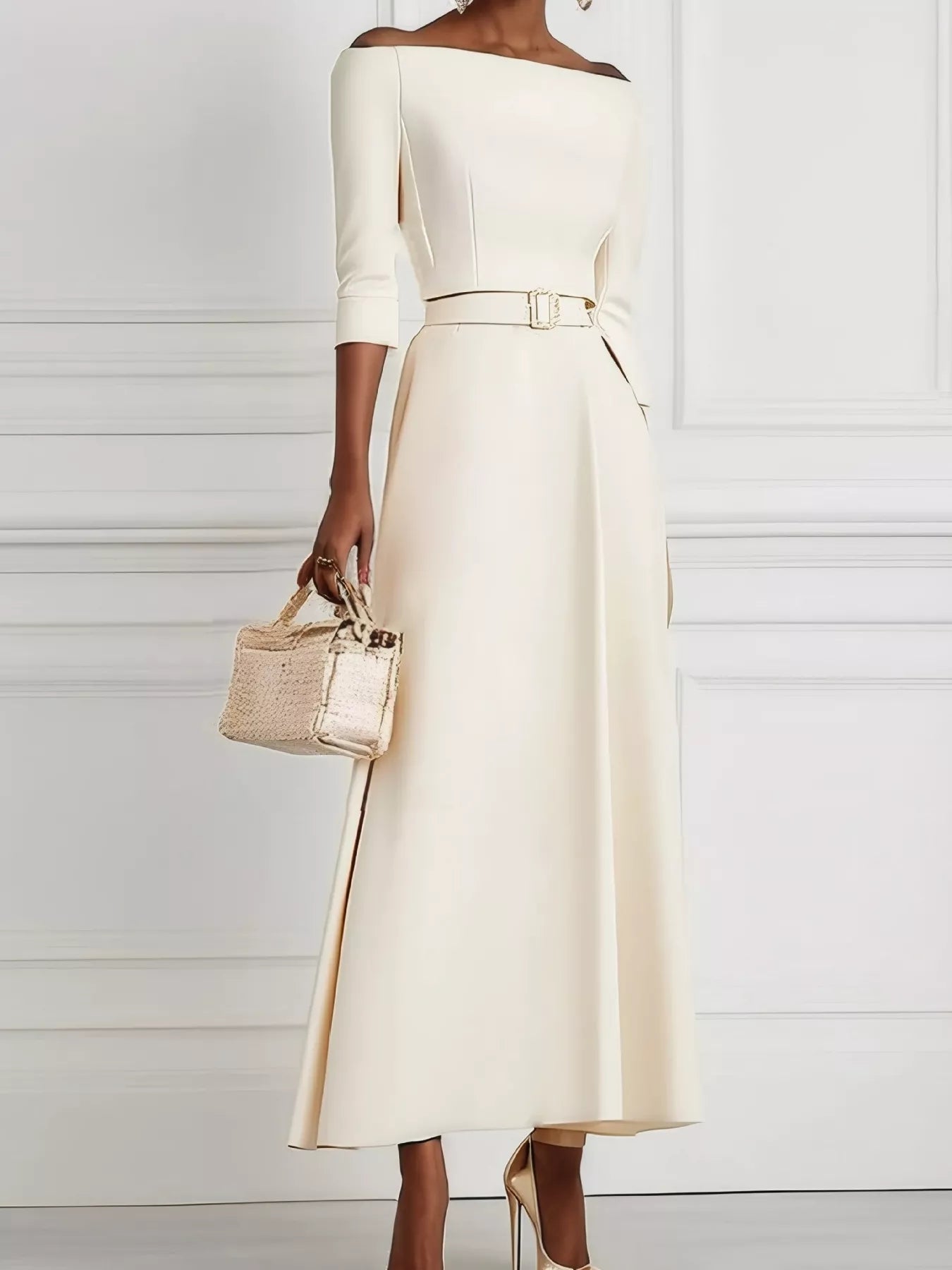 Woman wearing a white dress holding a beige handbag against a white background