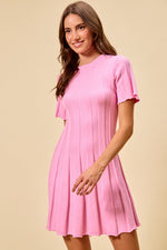 Woman wearing a pink dress against a beige background