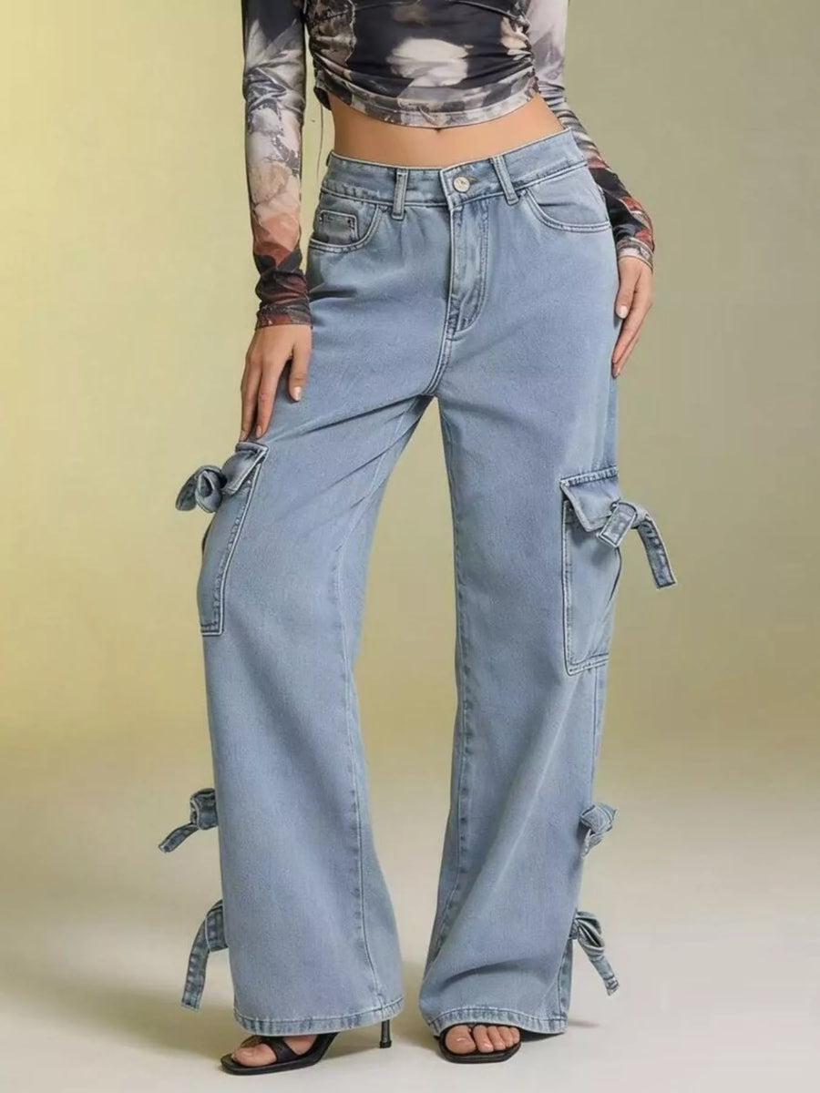 Person wearing light blue jeans with tie details on a beige background
