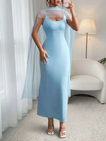 Woman wearing a light blue dress with sheer sleeves in a room.