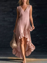 Woman wearing a pink dress with ruffled layers against a dark background