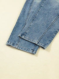 Folded blue jeans on a beige background