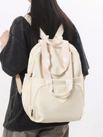 Person wearing a beige backpack on a plain background