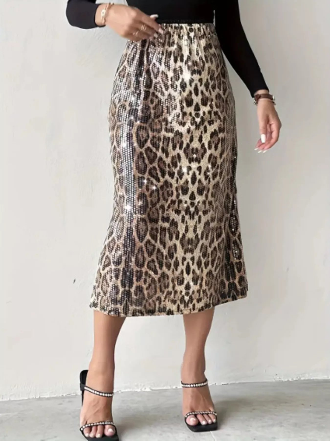 Person wearing a leopard print skirt with a plain background