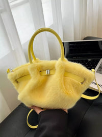 Yellow fluffy handbag held by a person with a blurred background