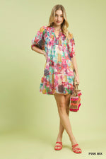 Woman wearing a colorful floral dress on a light green background