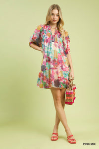 Woman wearing a colorful floral dress on a light green background