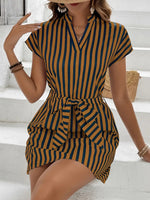 Woman wearing a striped dress sitting on white steps.