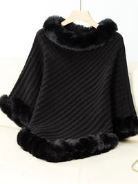 Black poncho with fur trim on a white background