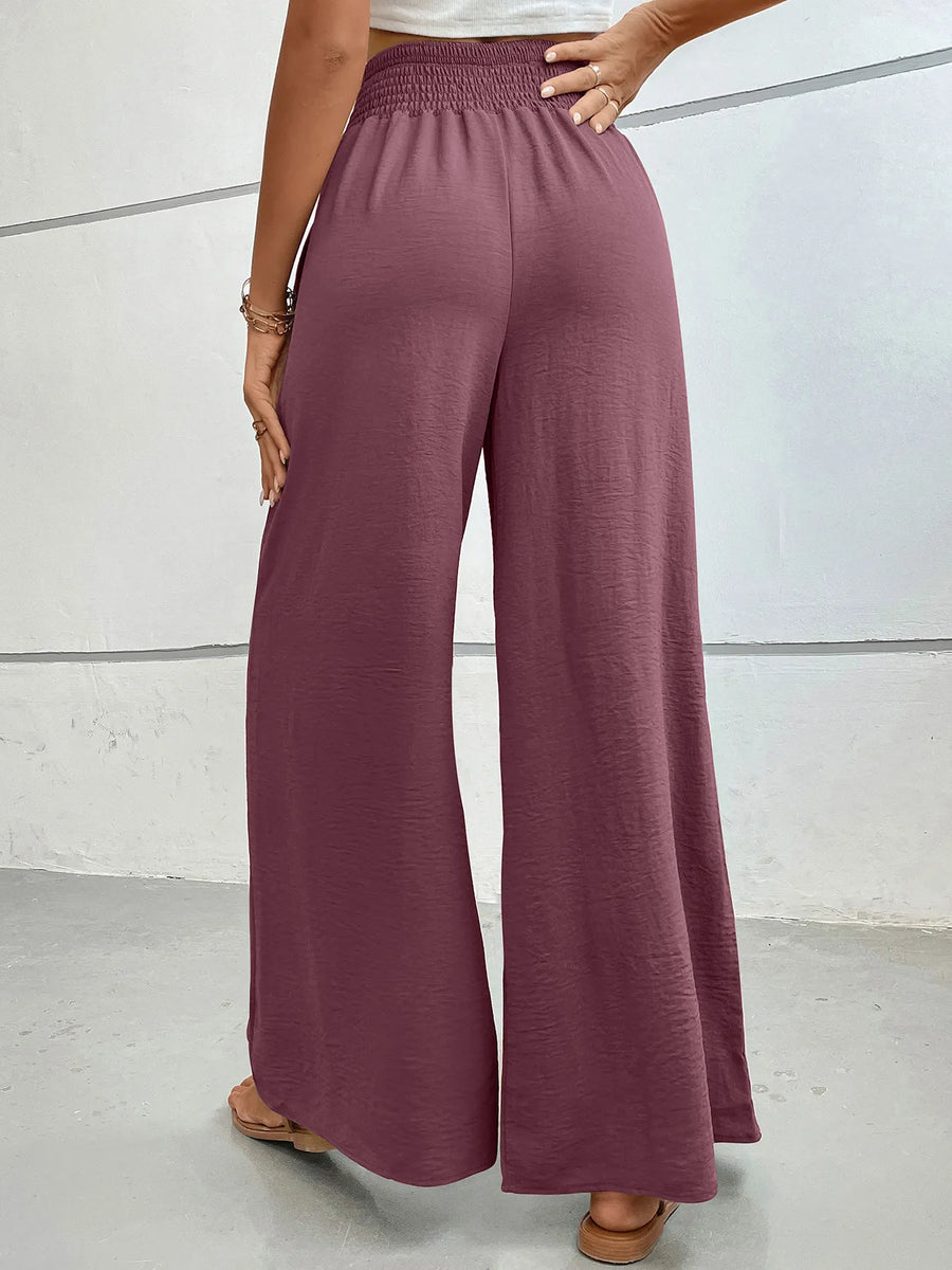 Person wearing mauve wide-leg pants against a neutral background